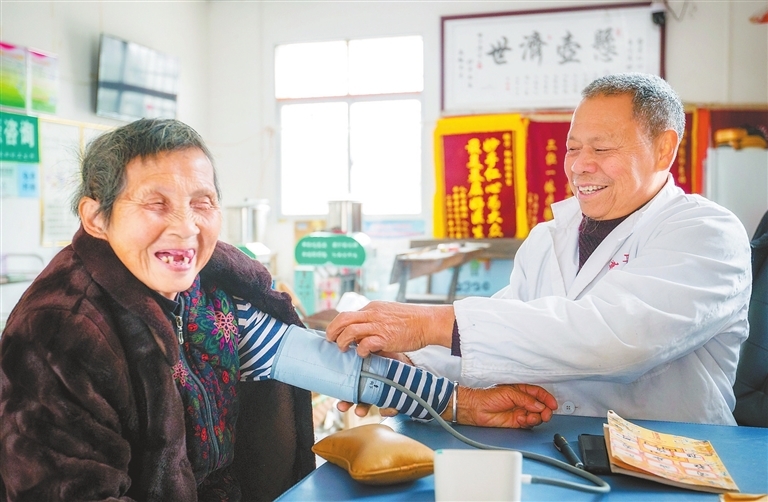 1月7日，万载县罗城镇麻田村卫生所，邬德祖一边给老人测量血压，一边和她拉起了家常。