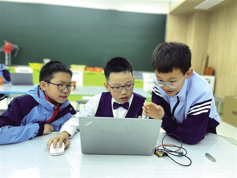 学生在西安市雁塔雁南小学创客教室学习机器人编程。