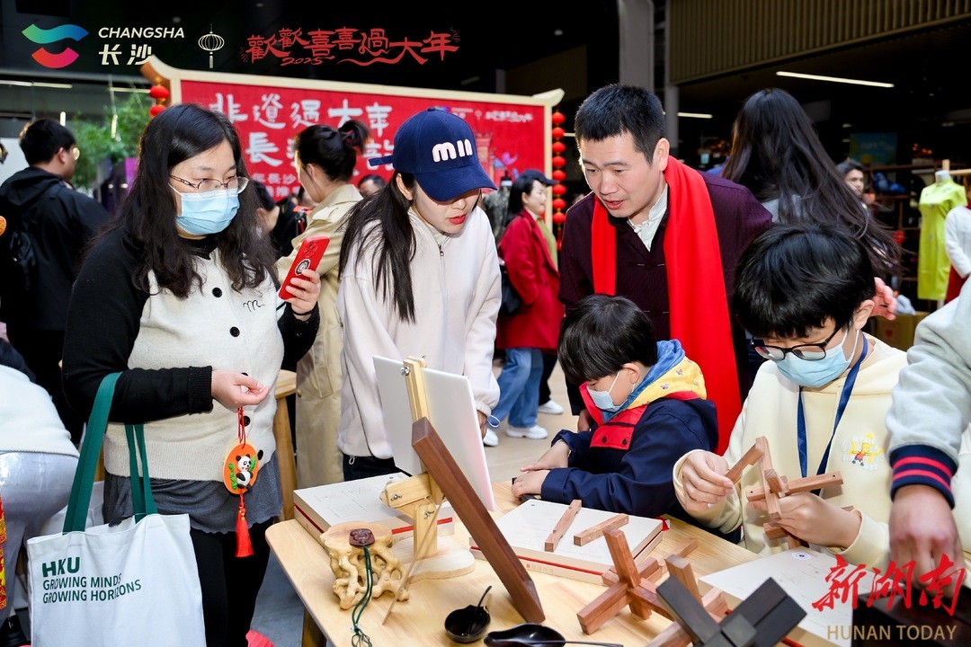 游客体验榫卯小木作结构技艺。