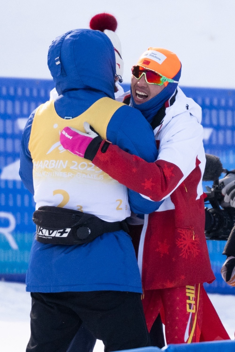 2月12日，中国队选手王强（右）冲过终点后与哈萨克斯坦队选手奥尔扎斯&middot;克利明（左）拥抱。新华社记者 伍志尊 摄