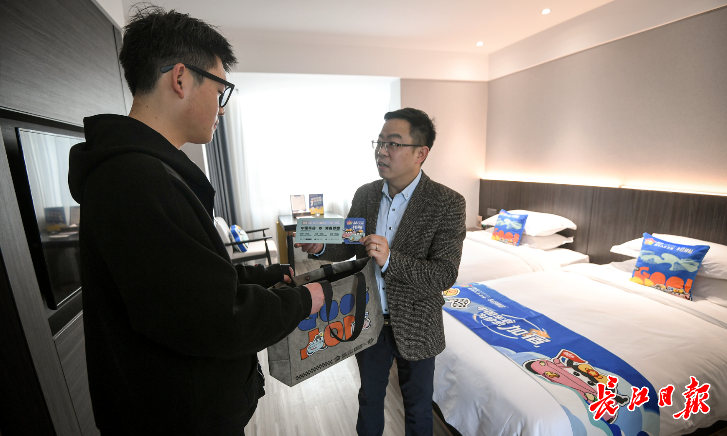 工作人员给刚刚入住的求职者储鑫送上文创礼袋。 记者史伟 摄