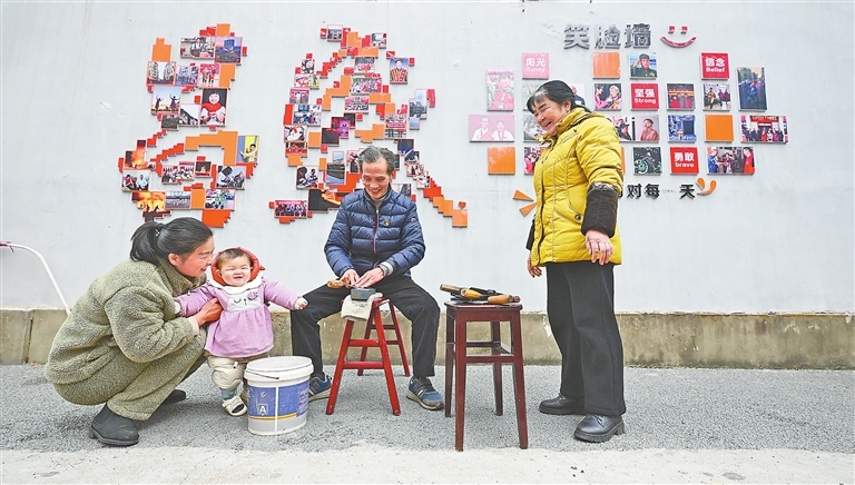 1月9日,萍乡市湘东区峡山口街道,陈德钧(右二)热心地为居民磨刀。他身后的笑脸墙上,挂满了近年来他为周边居民免费拍摄的照片。