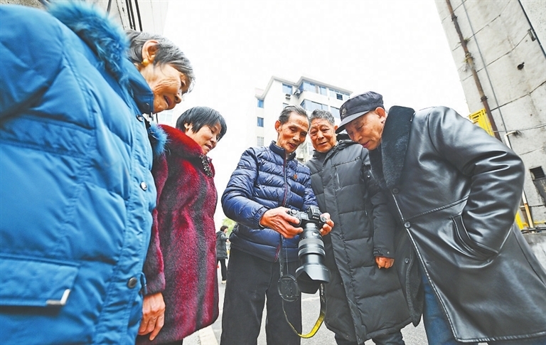 陈德钧向居民展示自己拍摄的照片。
