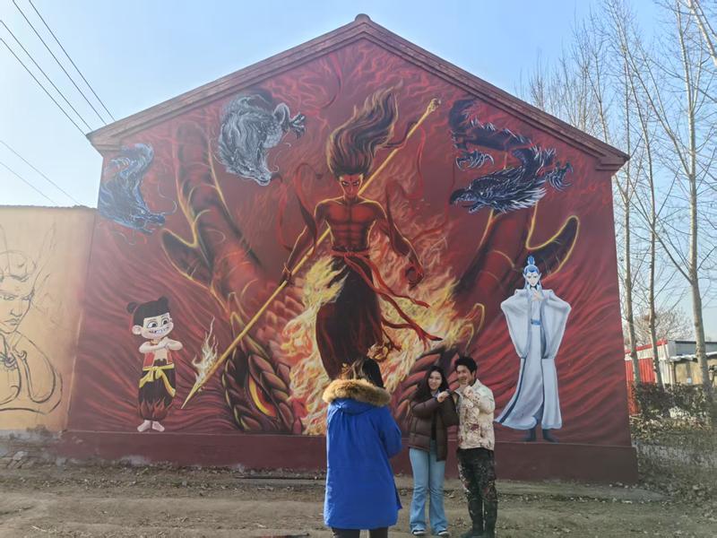 淄博市周村区城北路街道沈家村哪吒墙绘吸引游客前来打卡。 新华网记者 唐斓 摄