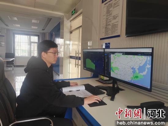 图为工作人员正在分析研判天气形势。 黄玉荣 摄