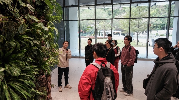 华大基因讲解员正向同学们介绍立体种植墙