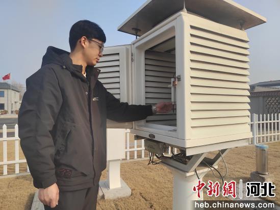 图为工作人员正在巡查百叶箱内仪器。 黄玉荣 摄