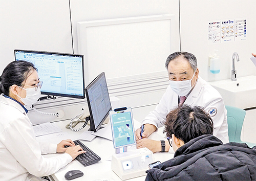 2月18日，在首都医科大学宣武医院河北医院，院长王玉平（右一）在知名专家诊区出诊。本报记者 李东宇摄