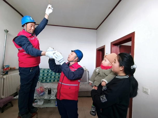 3月4日，国网灵寿县供电公司邢海明和志愿者为木佛塔村家庭检查更换用电设施。（单文忠 摄）