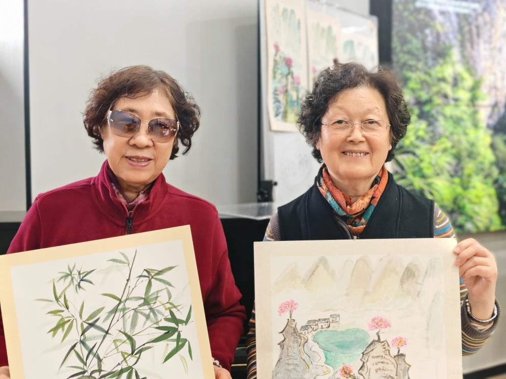 左一为孙阿姨,展示国画作品