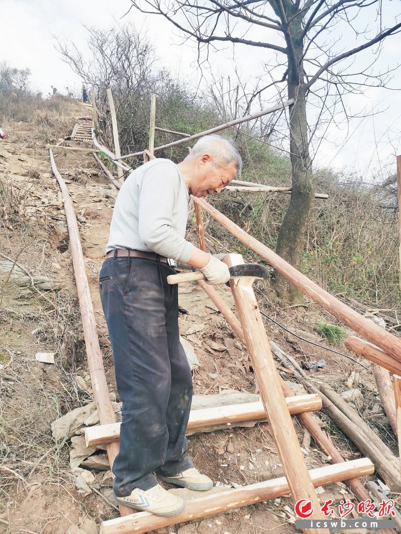 　　张爹爹正在尖山义务修登山梯。