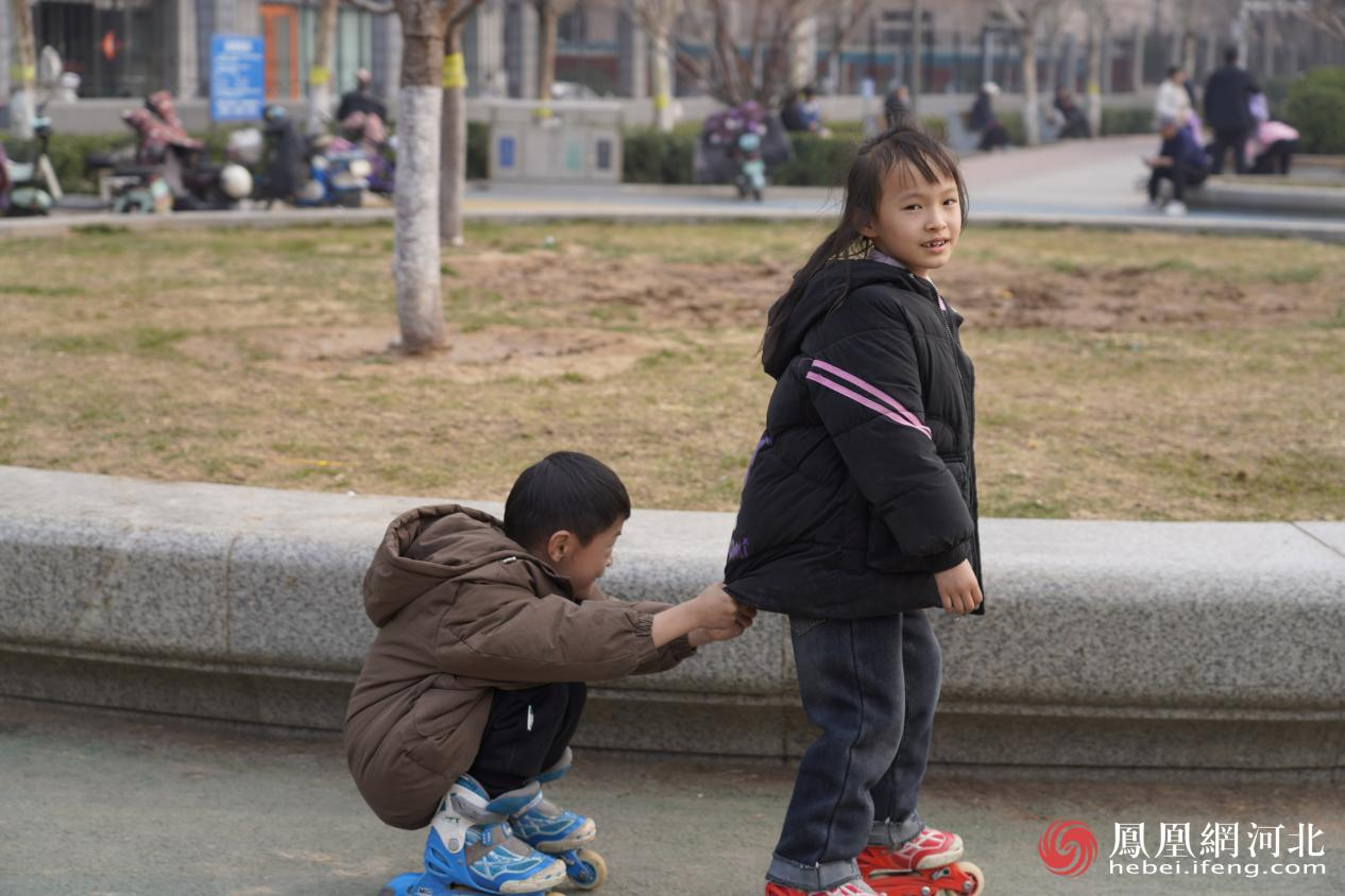 市民在民心河旁运动场景