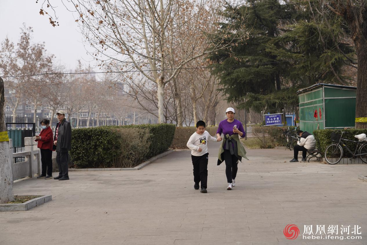 市民在民心河旁运动场景