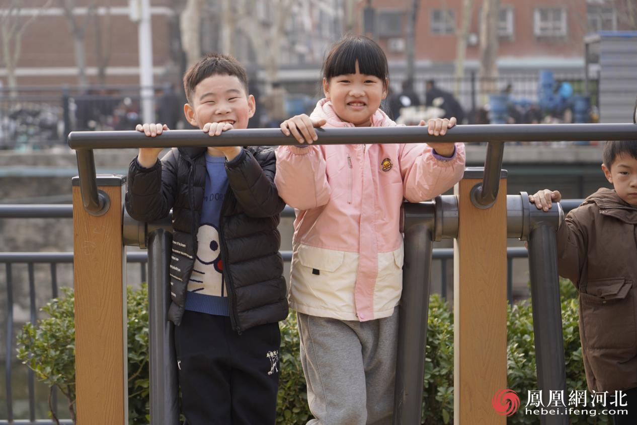 市民在民心河旁运动场景