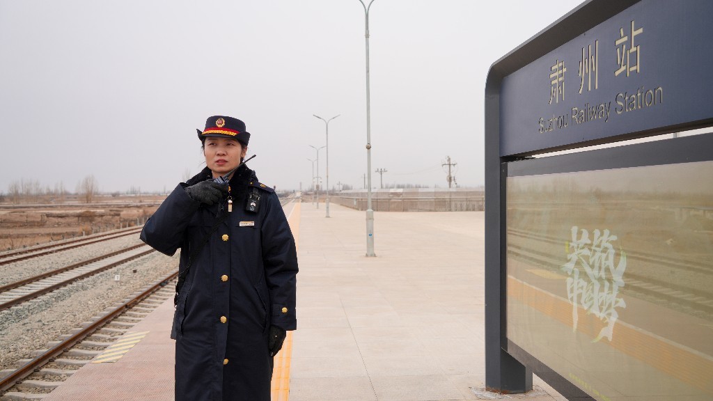 肃州站站台工作人员指引旅客乘车