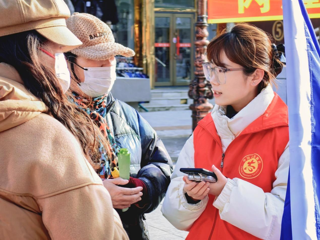 (建设银行伊春分行青年志愿者向市民介绍金融产品)