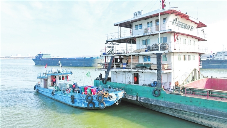 污染物流动接收船“赣瑞环1号”正在“打包”货轮“永宁998号”的生活垃圾和污水。