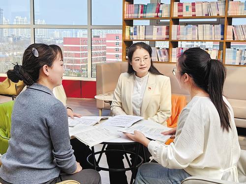 3月10日，代忖（右二）和青年教师交流研讨。本报记者 陈华摄