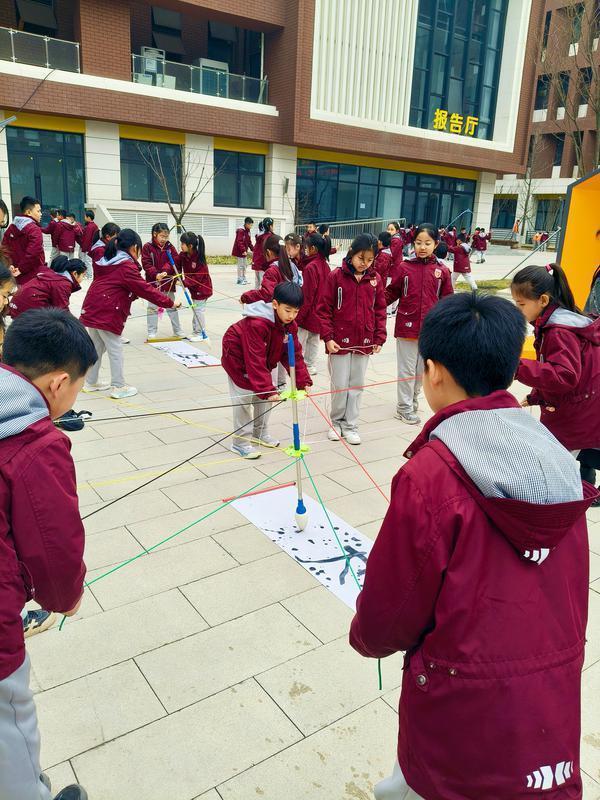 灞桥区纺织城小学的“神笔马良”游戏区，三年级五班的学生正分组齐心练书法。 记者 牛凌摄影