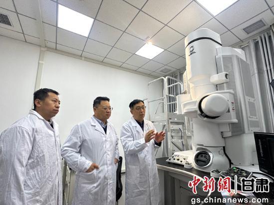 图为喇培清(中)与团队讨论科学实验 魏建军 摄