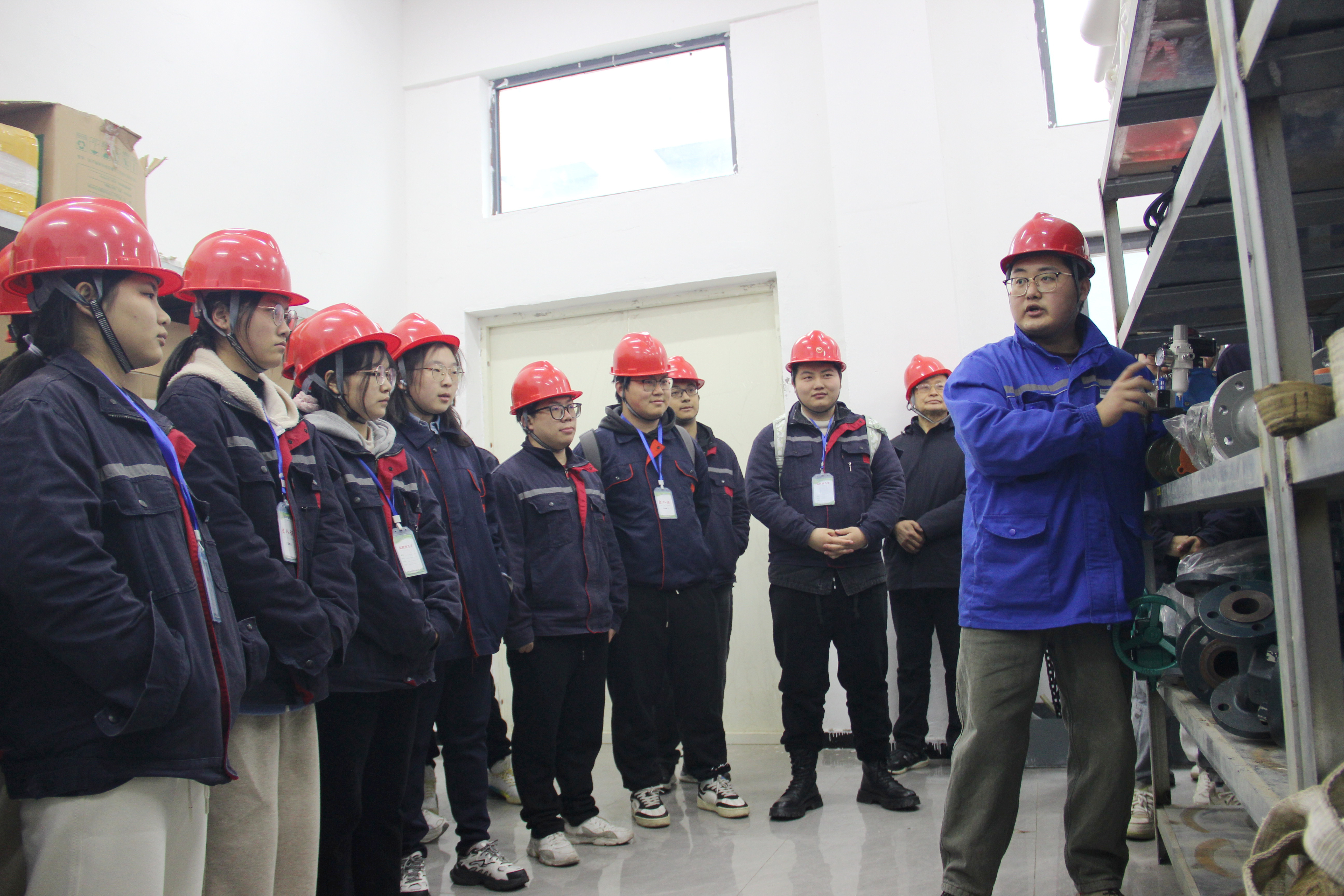 图为近日，在该县金轩科技企业生产设备储存库房，企业技术人员正在为前来实践的安徽理工大学的学生讲解生产设备的用途和操作要领。