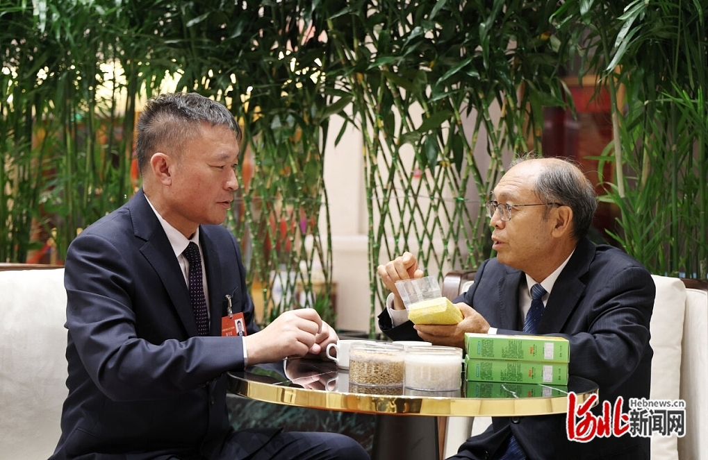 赵治海代表(右)与聂守军代表交流各自的最新育种成果。 河北日报记者 赵海江摄.jpg