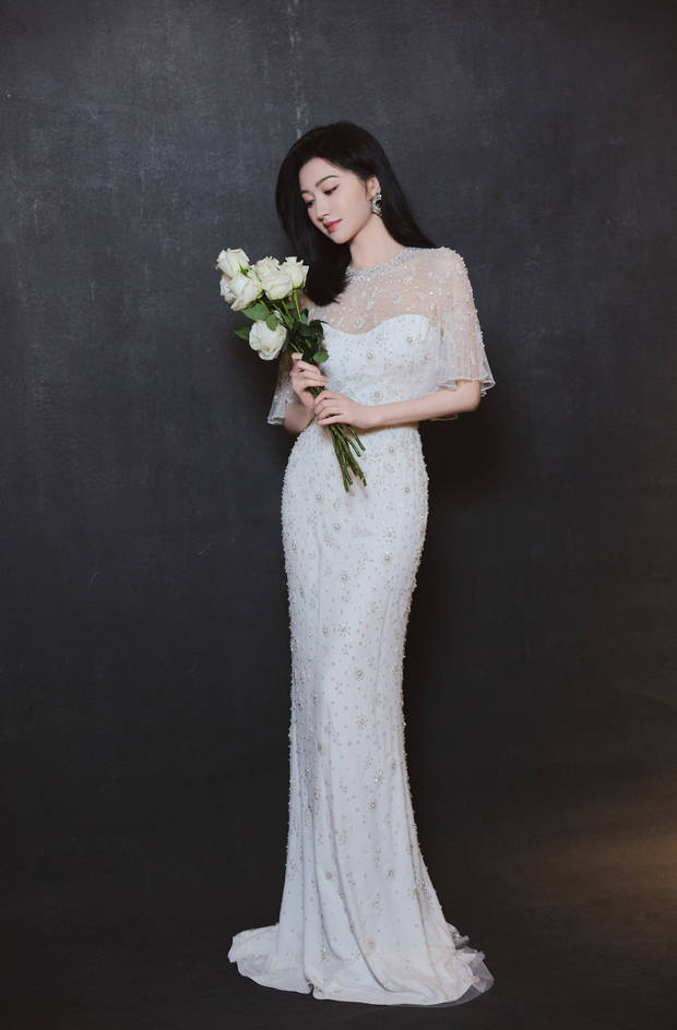 搜狐娱乐讯 8日，景甜在社交平台上晒出一组写真美照，她化身优雅白玫瑰美人，一袭珠饰长裙勾勒曼妙身姿，气质超好！