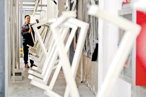 3月9日,位于衡水市冀州区的河北冀尚医疗器械有限公司喷涂共享工厂内,工人正在整理悬挂在喷涂吊挂线上的医疗床零部件。 本报记者 焦磊摄