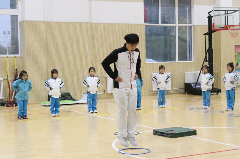 浐灞御锦城小学一年级学生在老师的带领下进行游戏化体能训练 记者 王佳玥摄影