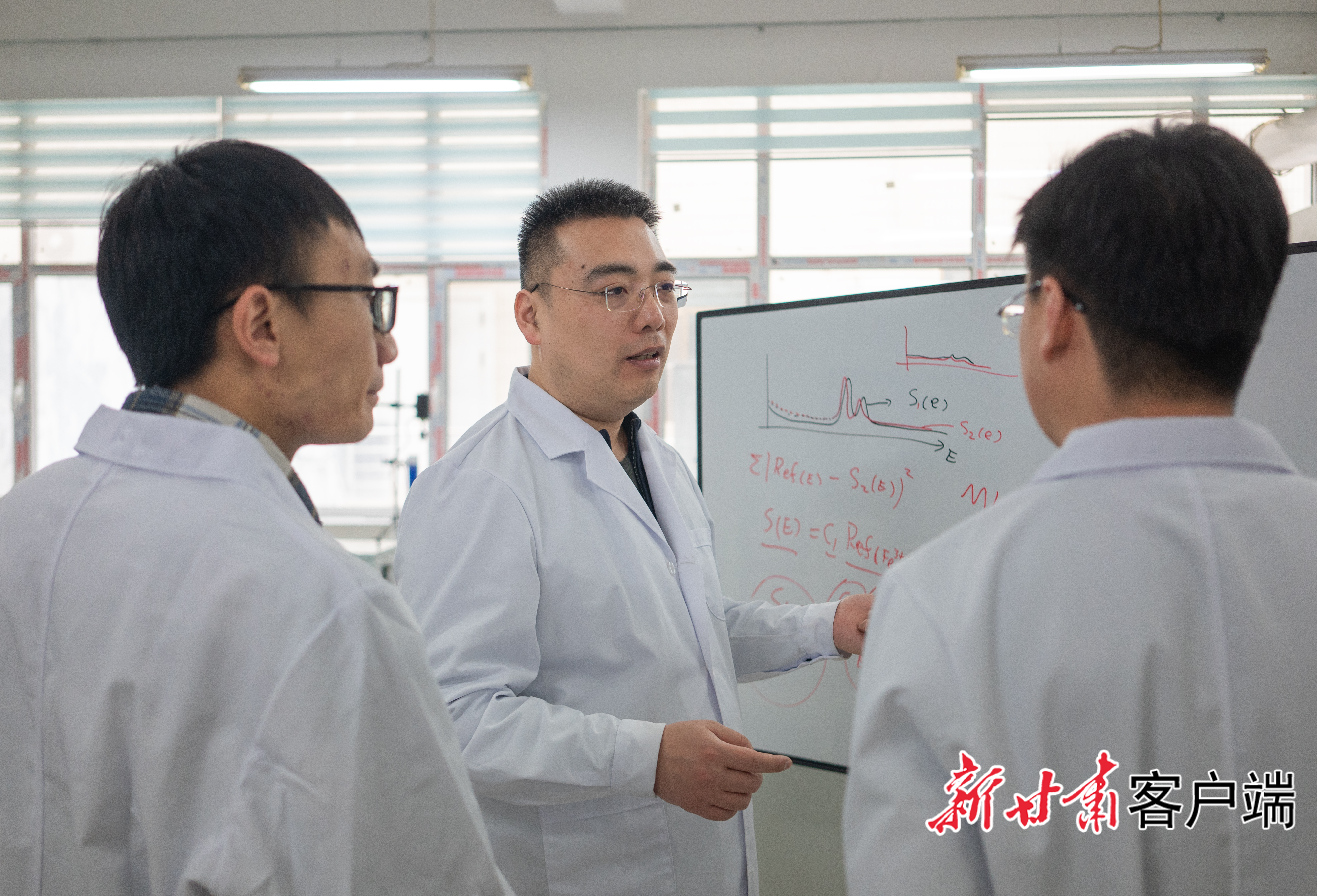 穆晓柯教授（中）和同事、学生讨论实验问题