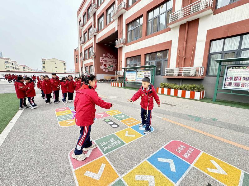 课间时间，灞桥区东城第三小学孩子们来到院落里玩跳方格 记者 牛凌摄影
