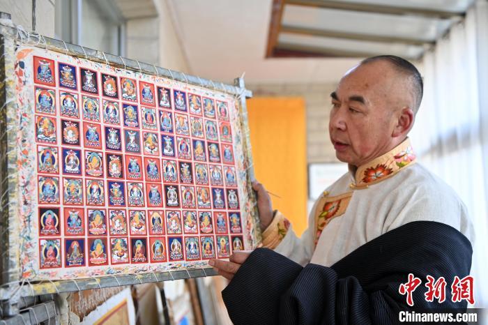 2024年2月2日，甘肃夏河，甘南藏族唐卡国家级代表性传承人交巴加布在家中展示其绘制的唐卡。（资料图）九美旦增　摄