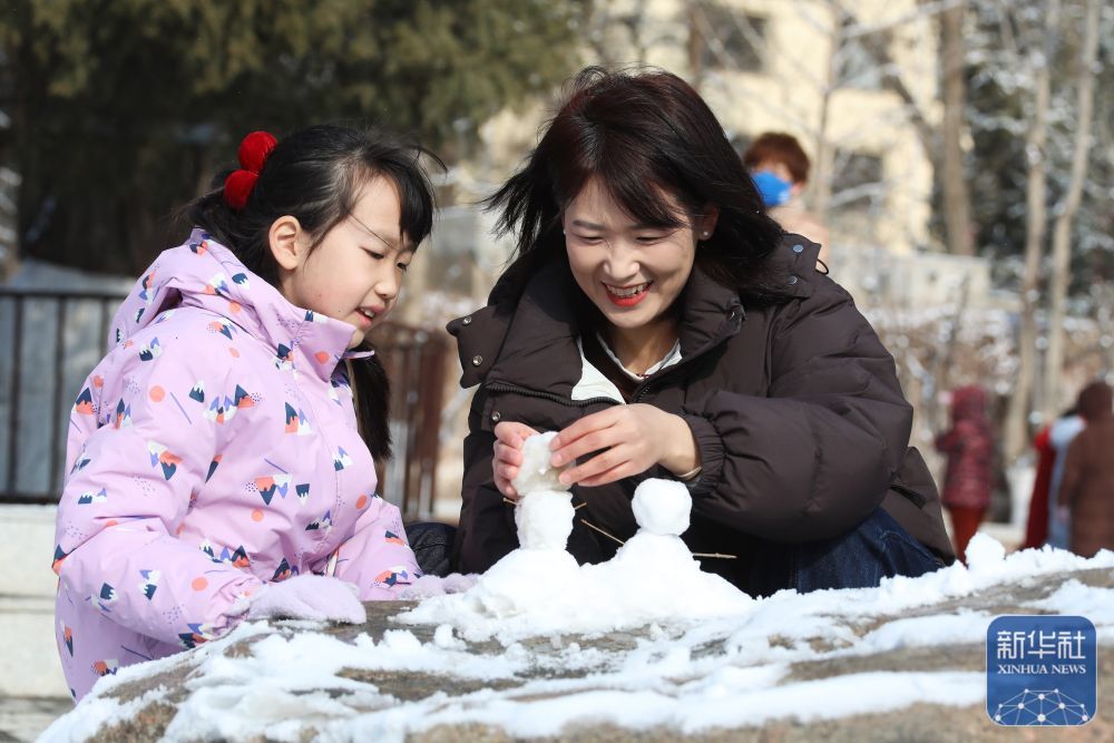 ↑3月15日，母女俩在河北省张家口市人民公园堆雪人。新华社发（武殿森　摄）