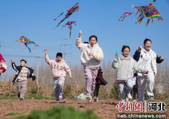 图为孩子们在田野里奔跑放风筝。 王倩倩 摄