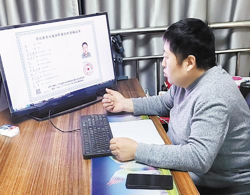 2月26日,在石家庄市长安区蕊源蜂业体验店,王岳峰向记者展示电子版《河北省专业技术职务任职资格证书》。本报记者 许君强摄