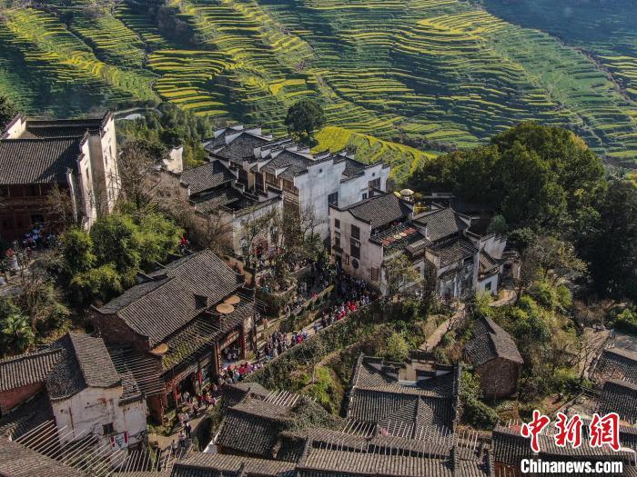 图为3月20日，航拍江西婺源县篁岭景区，近处的徽派古村落和远处的金色油菜花梯田交相辉映，风景秀美。刘力鑫 摄