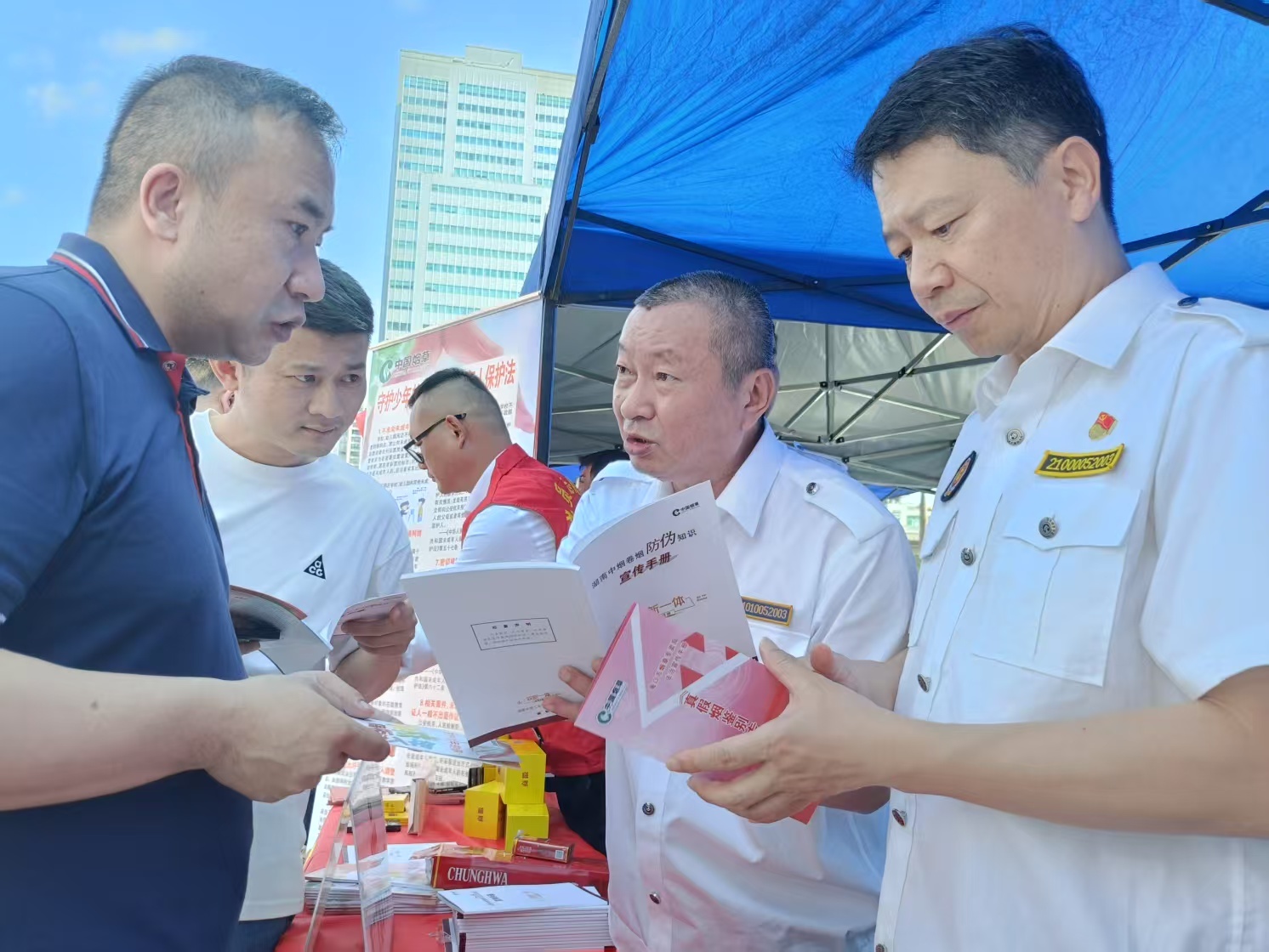 3月15日在海口万佳广场烟草专卖工作人员与市民交流普及相关烟草专卖方面的法律法规