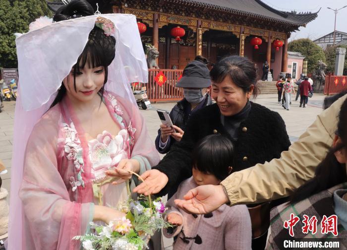 正在赠送鲜花给游客的“花神”。熊锦阳 摄