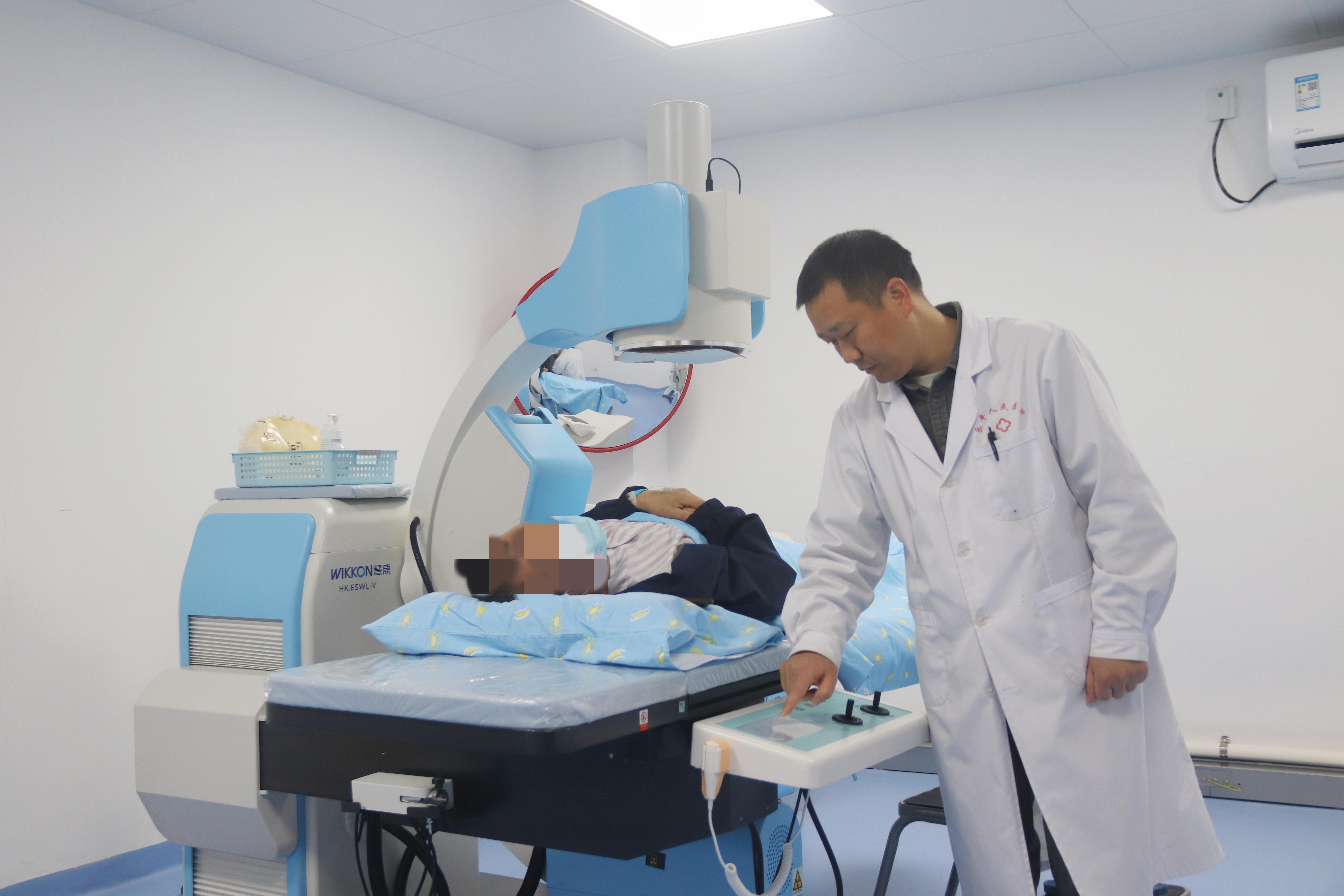 图:碎石科治疗室内,乐平医院医生正在询问患者情况和查看设备状态