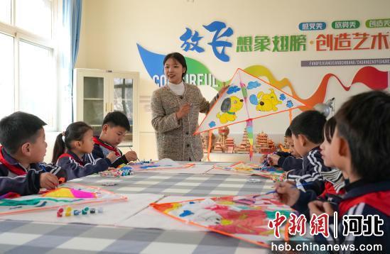 图为老师正在为孩子们讲解制作风筝的要领。 王倩倩 摄