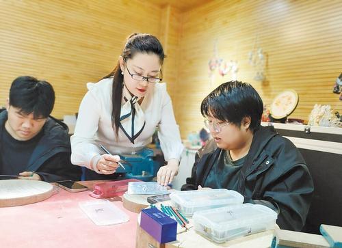 3月14日，郭墨涵（中）指导学生进行铁板浮雕创作。 本报记者 孙青摄