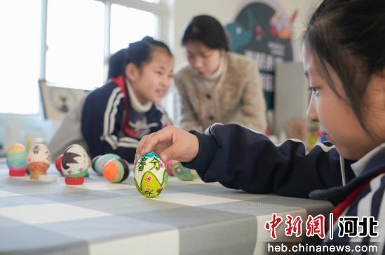 图为孩子们正在挑战竖蛋。 王倩倩 摄