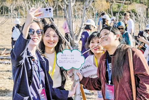 3月20日，中美学生在“中美友谊传承青年林”种下友谊之树并自拍留念。 本报记者 李东宇摄