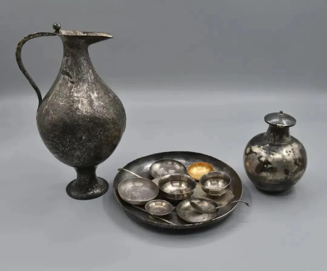 ▲武威慕容智墓出土装有白葡萄酒的银胡瓶及成套餐具