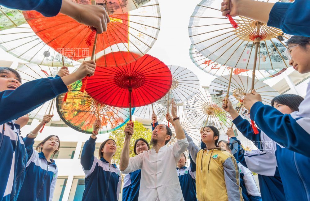 油纸伞非遗传承人为孩子们讲解油纸伞的历史与工艺，传授制伞技能。