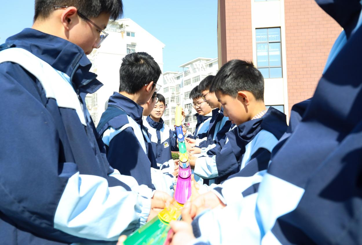 (图为:2025年3月25日,在安徽省合肥市肥西县上派镇安徽师范大学附属肥西第二中学校园内,学生们利用阳光大课间时间在操场上开展“球行万里”心理团辅游戏。)