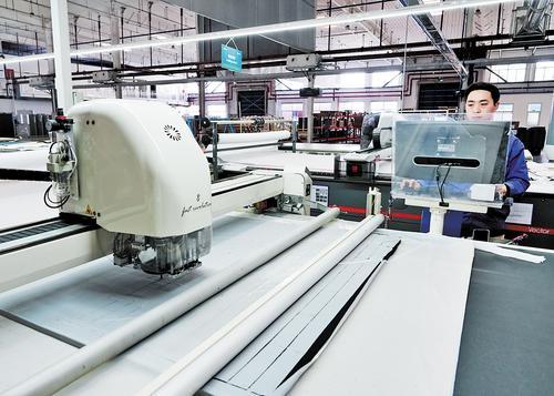 3月21日，在安道拓海纳川（河北）汽车部件有限公司车间内，工人正在进行面套裁剪加工。辛集市有关部门提供暖心服务，帮助该公司解决了外来员工子女入学问题，力促企业快速成长。