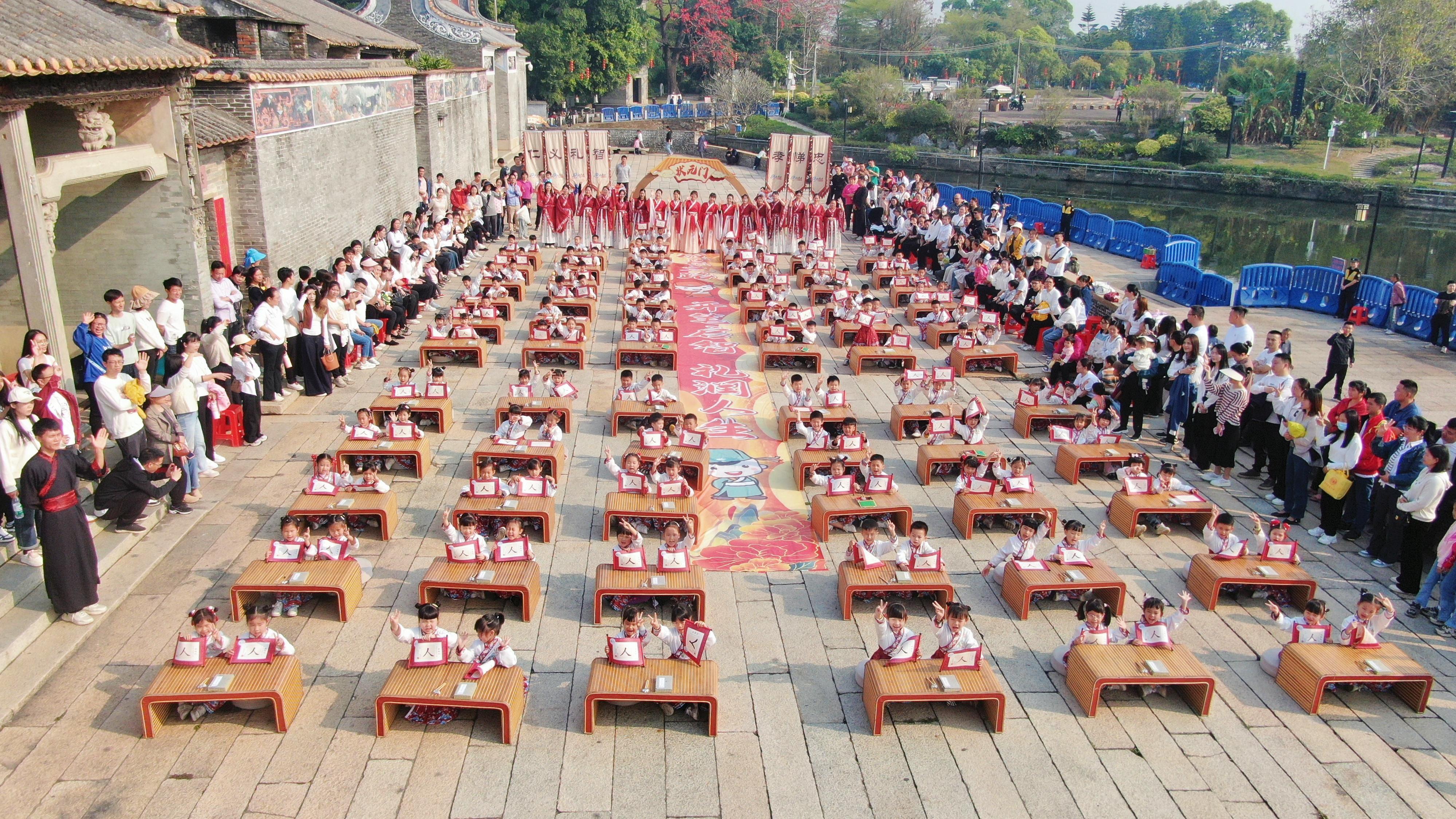 图：现场，学童们写下“人”字，感悟做学问首先要立身做人的道理