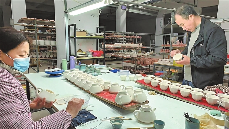 景德镇市柏采窑陶瓷有限公司生产车间内，员工在对上釉后的瓷坯进行检查。本报全媒体记者 王景萍摄