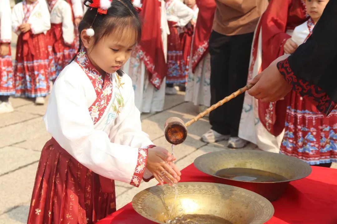 图：现场，学童们进行“净手礼”